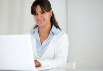 Smiling young woman working on laptop computer
