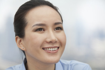 Close-up of smiling young woman looking up