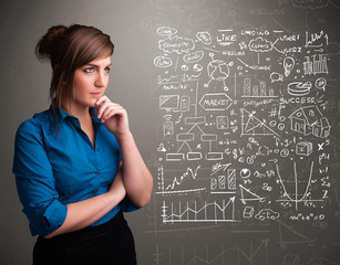 Fototapeta premium Pretty woman looking at stock market graphs and symbols