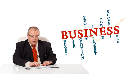 businessman sitting at desk and typing on keyboard with word clo