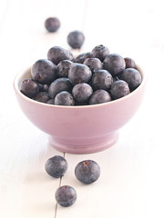 Frische Heidelbeeren auf einem weißen Holztablett.