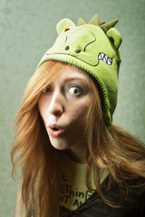 Surprised funny young woman with dragon hat