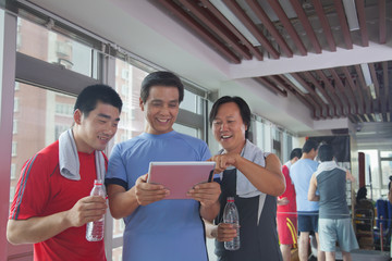 group of people looking at digital tablet in the gym 