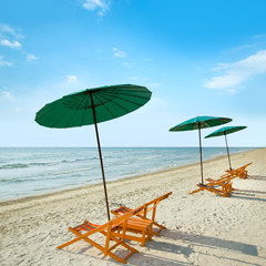 Beach chairs and umbrella on beach.