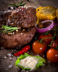 Delicious beef steaks on wooden table
