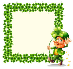 A man holding a clover leaf beside a frame made of leaves