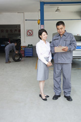 Fototapeta premium Garage Mechanic Explaining to Customer