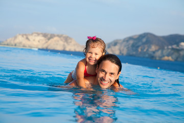 Fototapeta na wymiar Father with his daughter swimming in pool