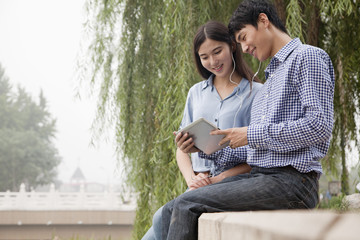 Fototapeta premium Couple Looking at Tablet Together