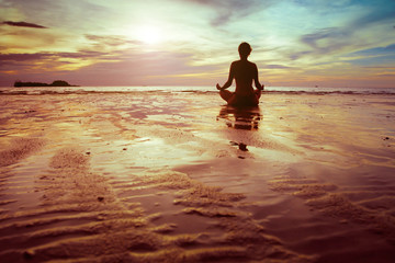 sport and fitness, silhouette of woman meditating on the beach
