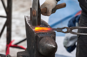Blacksmith forges iron in the forge