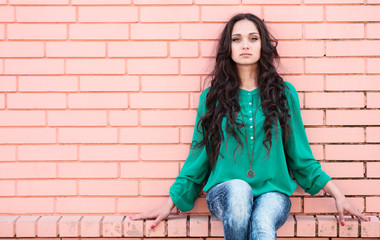 Young elegant woman in front of brick wall backround