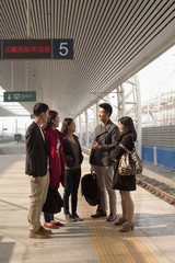 Group of people talking on railway platform