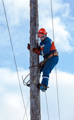 electrician climbs a power pole