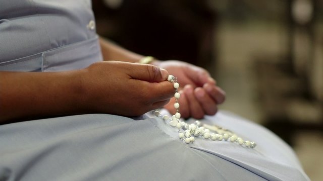 Woman and religion, catholic sister praying in church