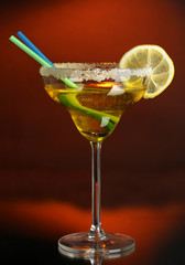 Yellow cocktail in glass on color background