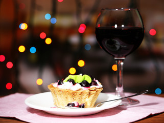 Tasty blackberry cake and glass of red wine,