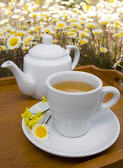 White cup and teapot with flowers