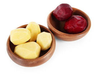 Peeled vegetables in wooden bowls isolated on white