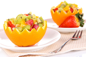 Fruit salad in hollowed-out orange isolated on white