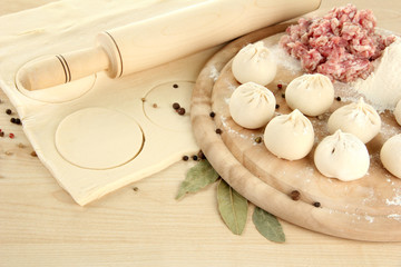 Raw dumplings, ingredients and dough, on wooden table