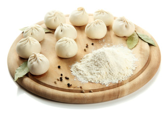 Raw khinkali on wooden desk, isolated on white