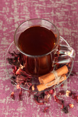 Herbal tea in glass cup, on color wooden background