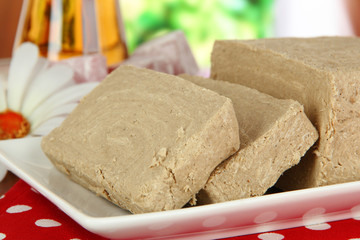 Tasty halva with tea on table in room