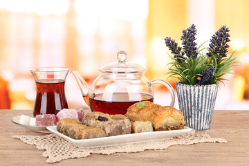 Sweet baklava on plate with tea on table in room
