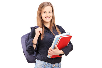 A female student with backpack holding notebooks