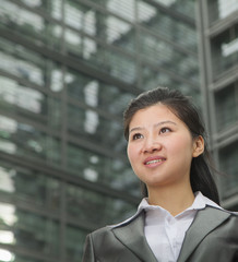 Portrait of young businesswoman outdoors among skyscrapers