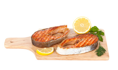 Grilled salmon with lemon and herbs on cutting board
