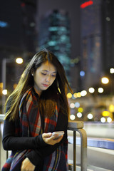 woman use mobile phone in city at night