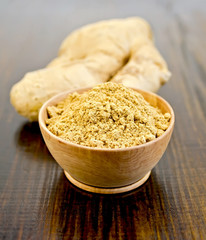 Ginger powder in a bowl with the root