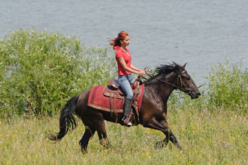 Equestrian woman horseback riding on beach