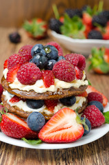 Pancake cake with whipped cream,  fresh berries closeup