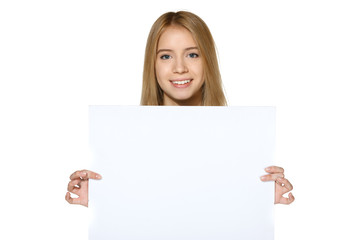 Naklejka premium Smiling teen girl holding blank white paper