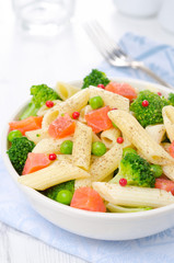 salad with pasta, smoked salmon, broccoli and green peas closeup