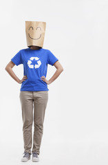 Young woman with smiley face paper bag over her head