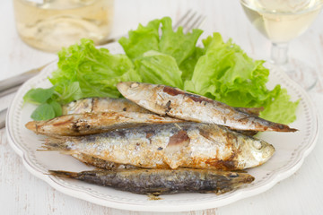 fried fish with salad on the plate