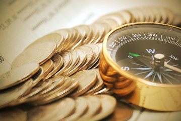 Coins and compass on bank book account in vintage color
