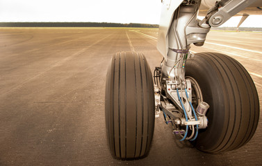 Landing gear, wheels, on the runway, close up - obrazy, fototapety, plakaty