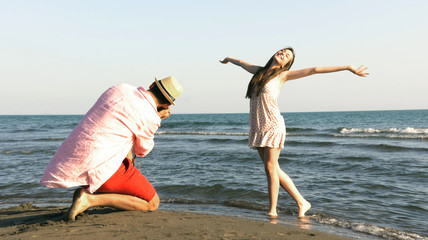 A cheerful couple fooling around on the beach