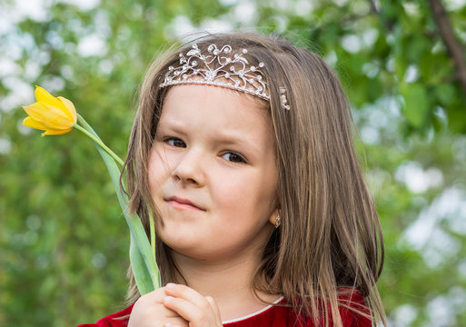 baby girl in the garden with a yellow flower