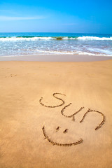 Word Sun and Smiley Written in Sand on Tropical Beach