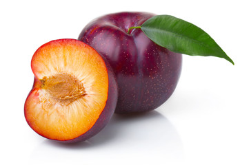 Ripe purple plum fruits with green leaves isolated