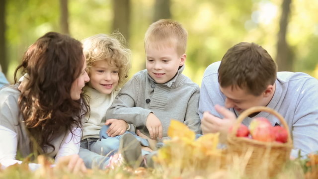 Happy family playing outdoors in autumn park