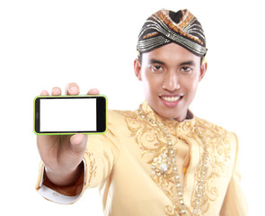 man with traditional java suit using mobile phone
