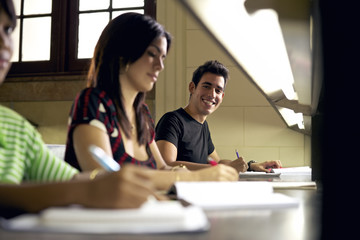 Happy student studying and writing, portrait of hispanic young m