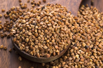 Buckwheat seeds on wooden spoon in closeup